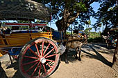 Inwa, Myanmar - tourists ride on a horse-drawn carriage. Riding on a horse cart is the easiest way to get around Inwa's narrow and dusty road to explore scatterred attractions. 